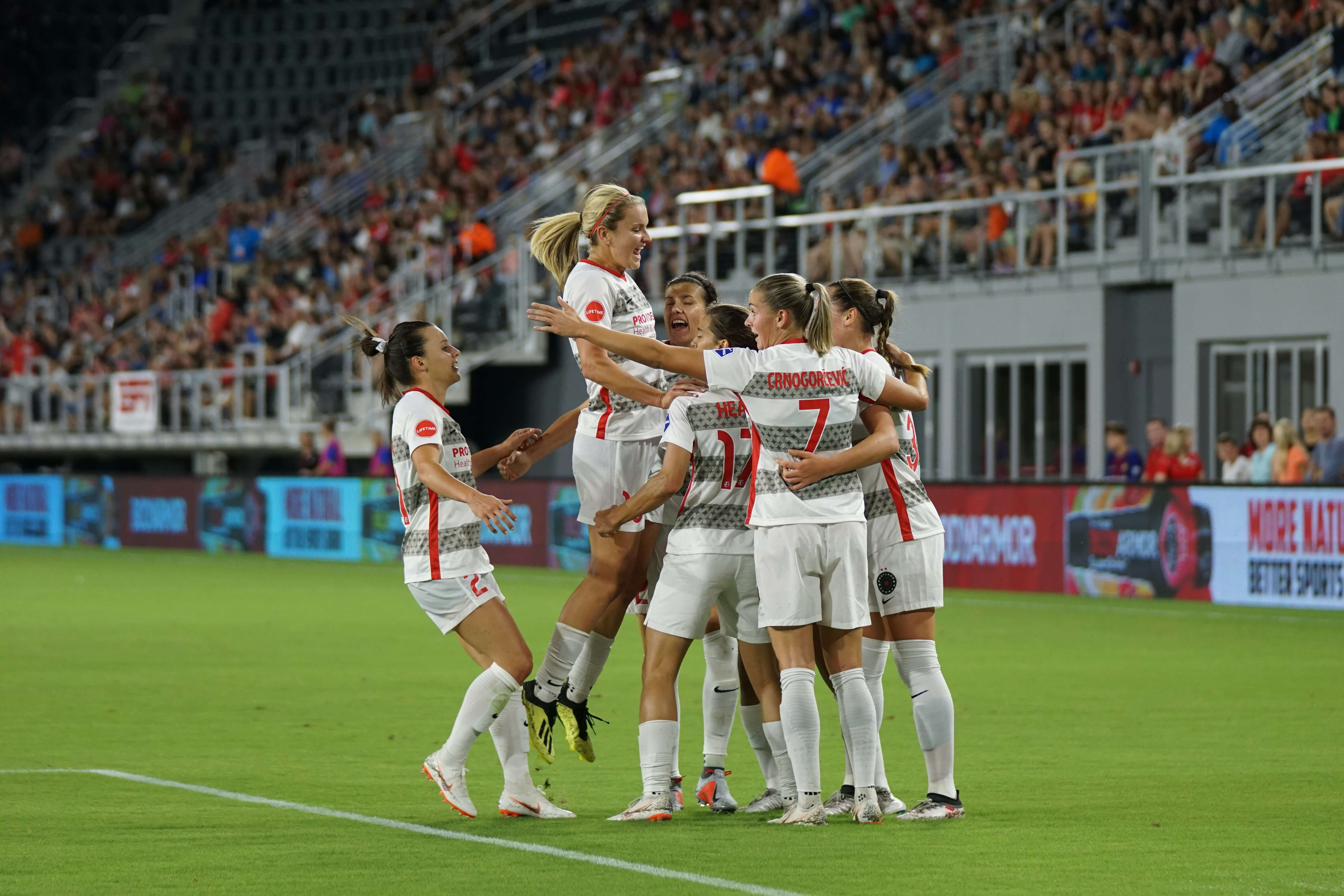 Football team celebrating a goal together on the pitch