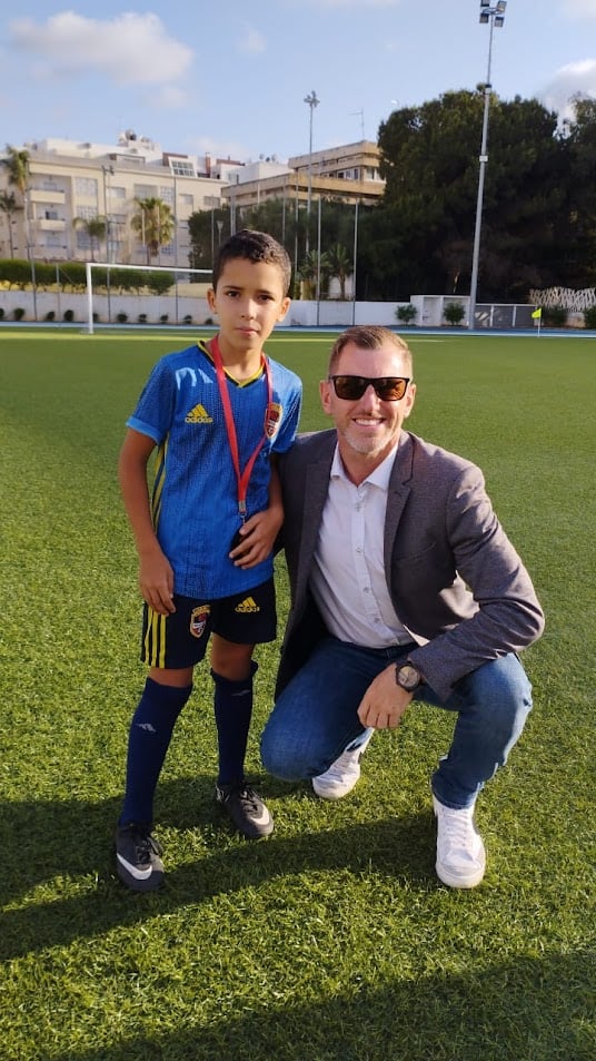 Young football player showing confidence walking onto the pitch on match day